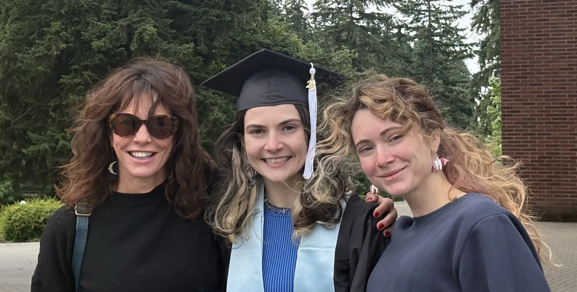 Woman graduating with mother and sister by her side